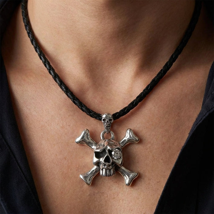 Mens sterling silver skull pendant necklace with crossbones worn on neck with dark shirt