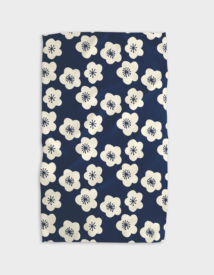 Navy kitchen tea towel with a white floral pattern on it, displayed on a white background.