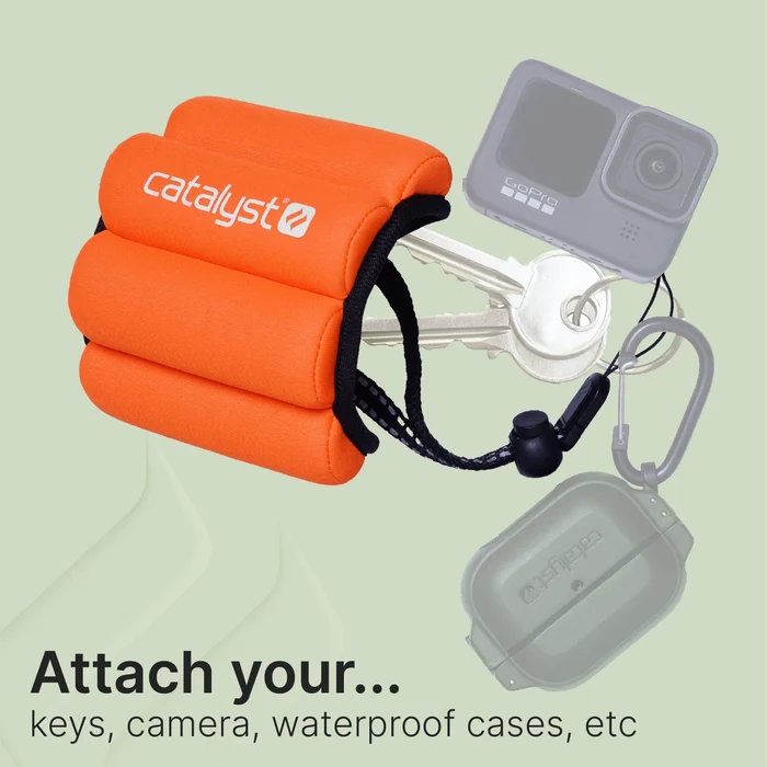An orange Catalyst Case US Floating Wrist Lanyard with adjustable cord is shown holding keys, a GoPro camera, and a waterproof case. The light green background displays: “Attach your… keys, camera, waterproof cases, etc.â€ÂÂ.