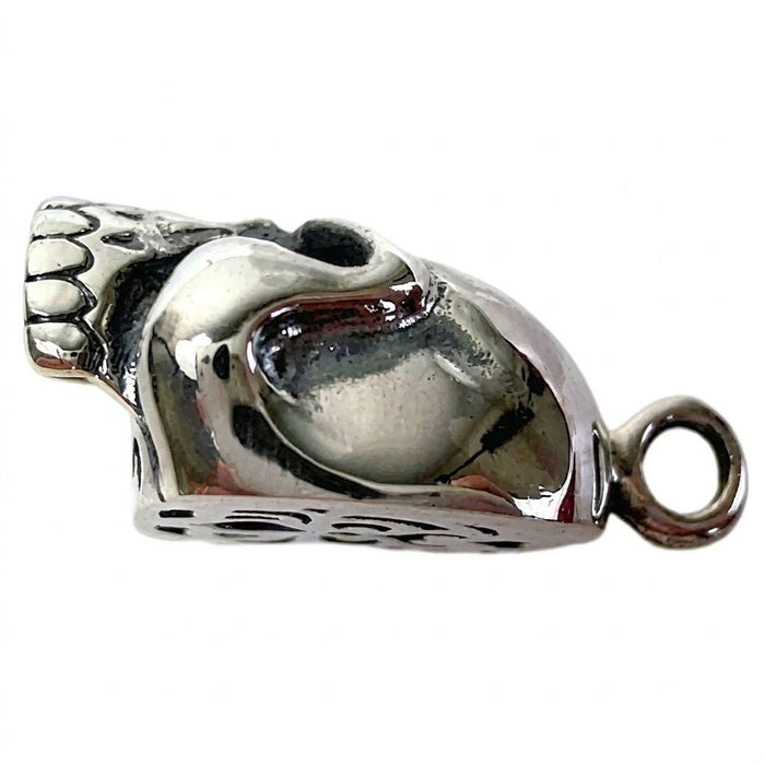 Left profile highlighting the mirror-bright sterling silver half of the skull pendant, deep eye socket, and bail ring.