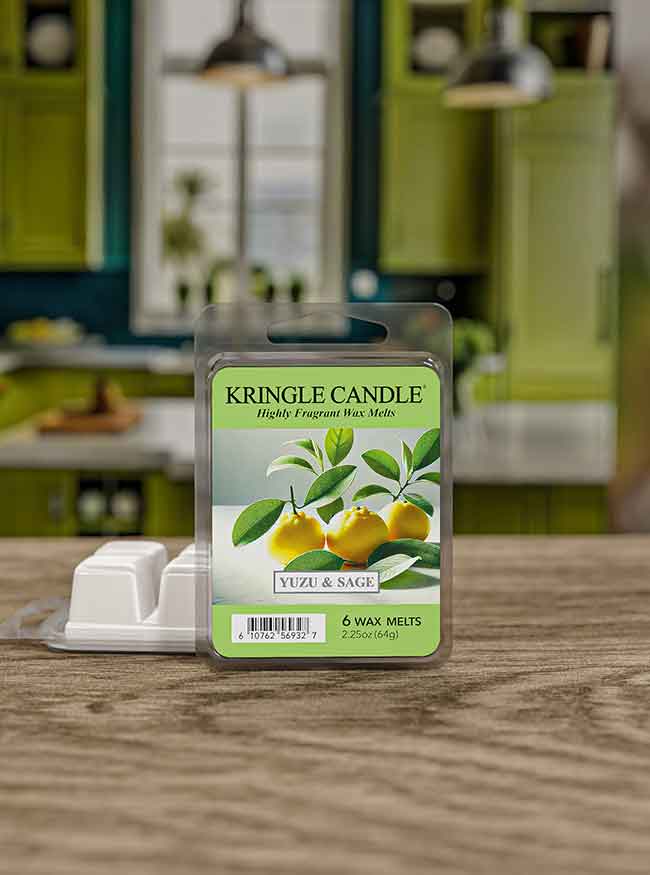 Pack of Kringle Candle Yuzu & Sage wax melts on a wooden table with a blurred kitchen background.