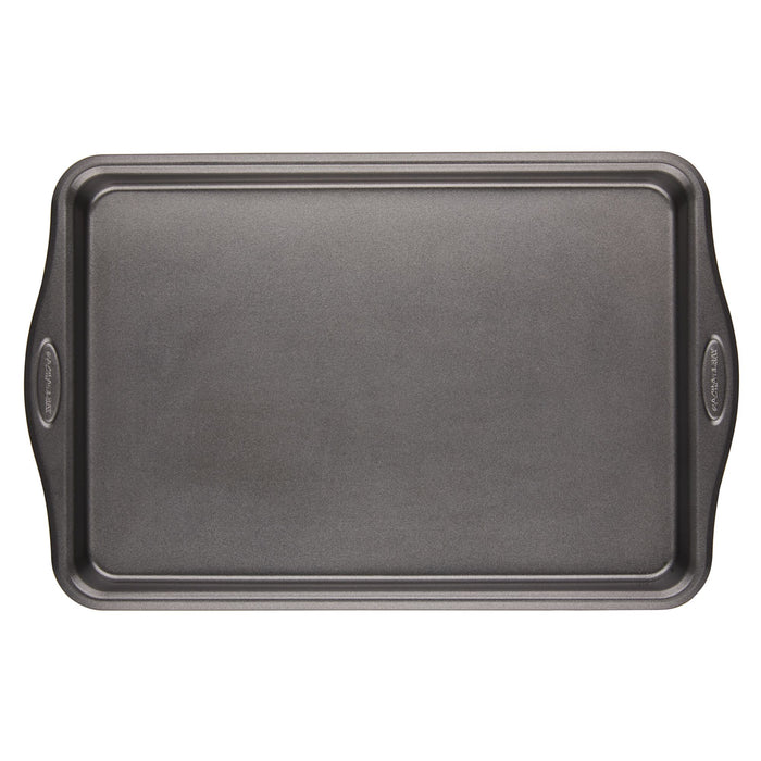 A piece from the 10-Piece Cook + Create Hard Anodized Nonstick Cookware Set, featuring a rectangular nonstick metal baking sheet with handles made from hard-anodized aluminum, rests on a pristine white background.