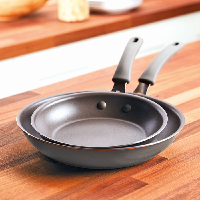 A 2-Piece Cook + Create Nonstick Frying Pan Set elegantly displayed on a wooden kitchen countertop.