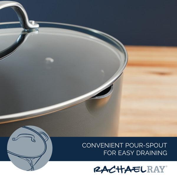 The 8-Quart Professional Nonstick Oval Hard Anodized Stockpot, complete with a glass lid and pour spout for easy draining, is elegantly resting on a wooden surface.