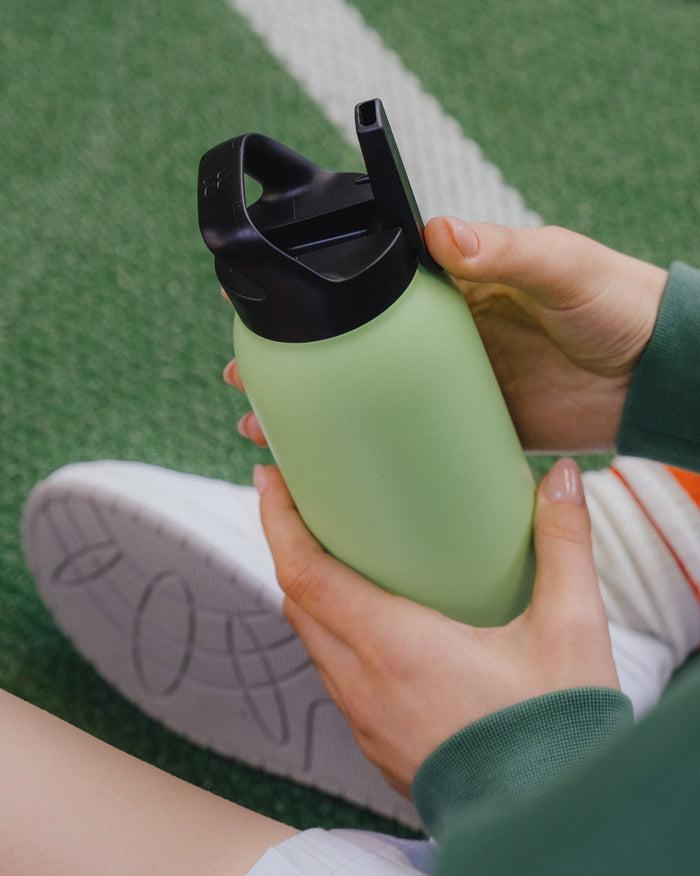 Juicy Duo Bottle Set with straw lid on turf.