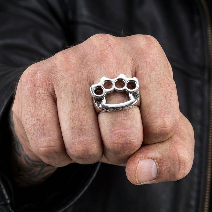 Sterling silver knuckle duster ring worn on clenched fist with leather jacket