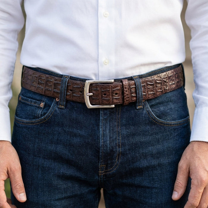 Man wearing the brown crocodile backbone belt through dark denim jeans with a white shirt, silver prong buckle centered