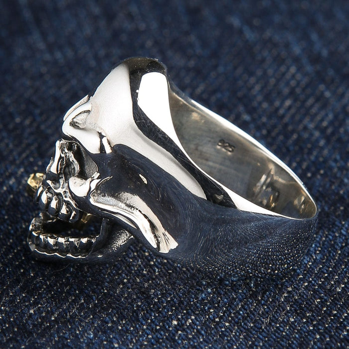 A unique two-tone skull ring in highly polished silver with a detailed gold cigarette.