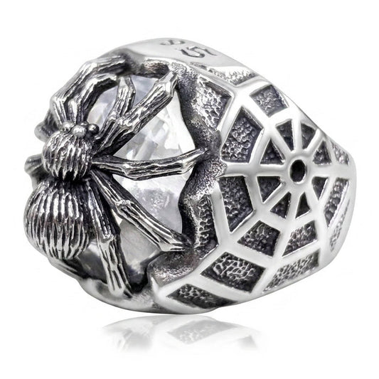 Sterling silver spider ring at three-quarter angle, oxidized web band wrapping a clear cubic zirconia stone