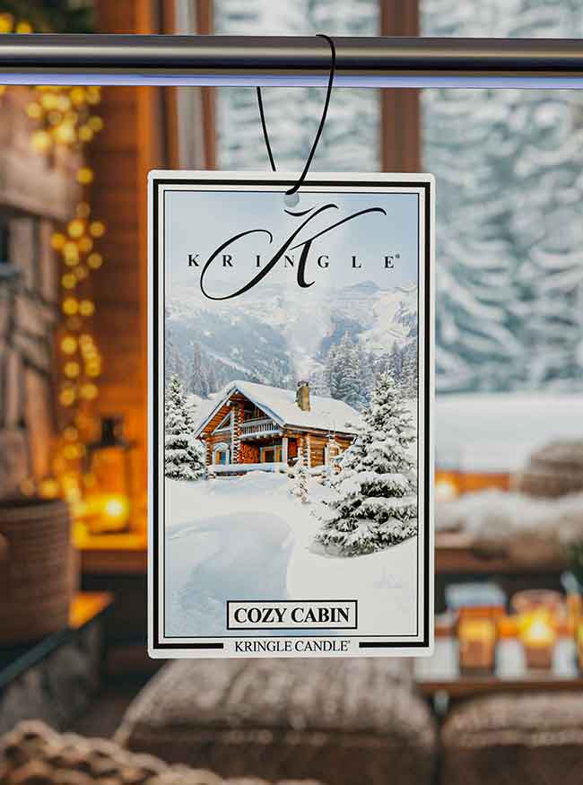 Kringle Cozy Cabin air freshener with a snowy cabin background