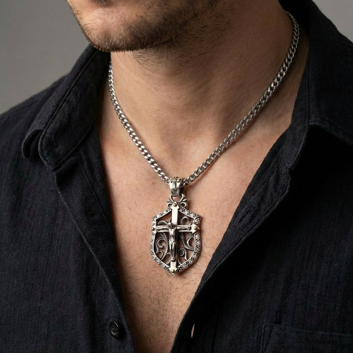 Man wearing handcrafted sterling silver crucifix shield pendant on silver Cuban curb chain with black shirt