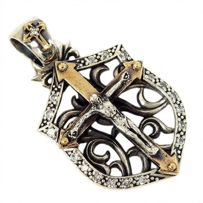 Angled view of sterling silver crucifix shield pendant showing filigree scrollwork and gold-tone brass cross accents