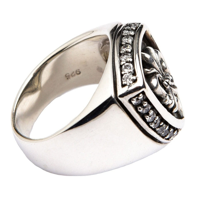 Top-down view focusing on the intricate fleur de lis emblem and oxidized background.