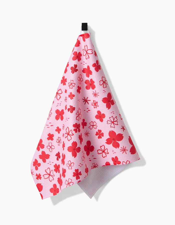 red floral towel hanging against white background