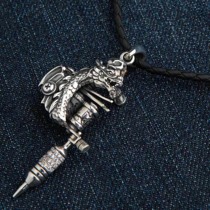The men's tattoo artist pendant featuring a detailed dragon, shown hanging on leather cord.