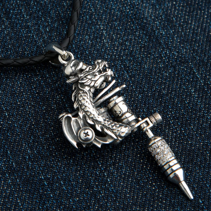 A side view of the silver dragon pendant, showing the intricate scales and the way it wraps around the tattoo machine.