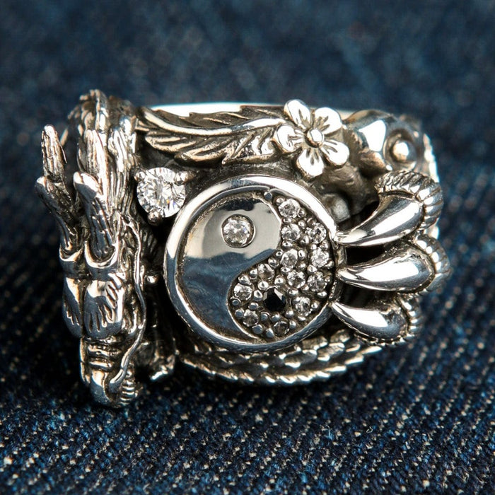 Dragon yin yang sterling silver ring with clear stones front view on denim