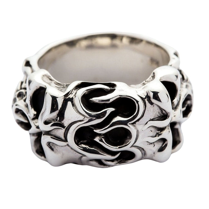 Front view of the sterling silver flame skull ring, showing carved tribal flames across the face of the wide band.