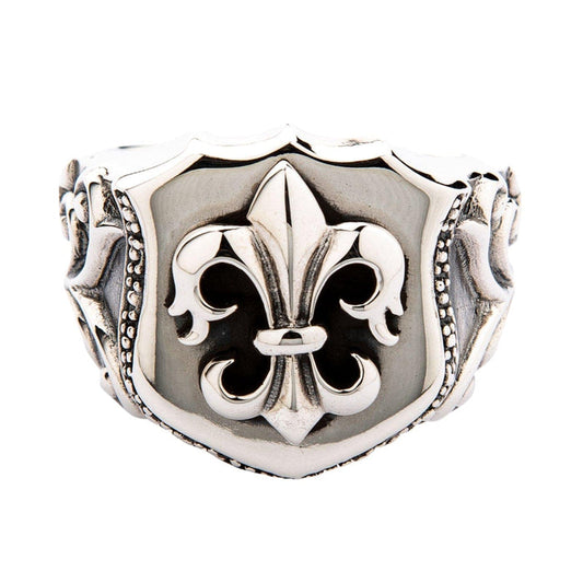 A solid sterling silver Fleur-de-lis shield ring with a polished 3D emblem and ornate side details.