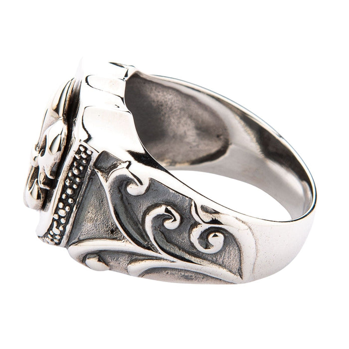 Scrolling engraving runs the length of the band, beading edges the shield, and the interior stays smooth.