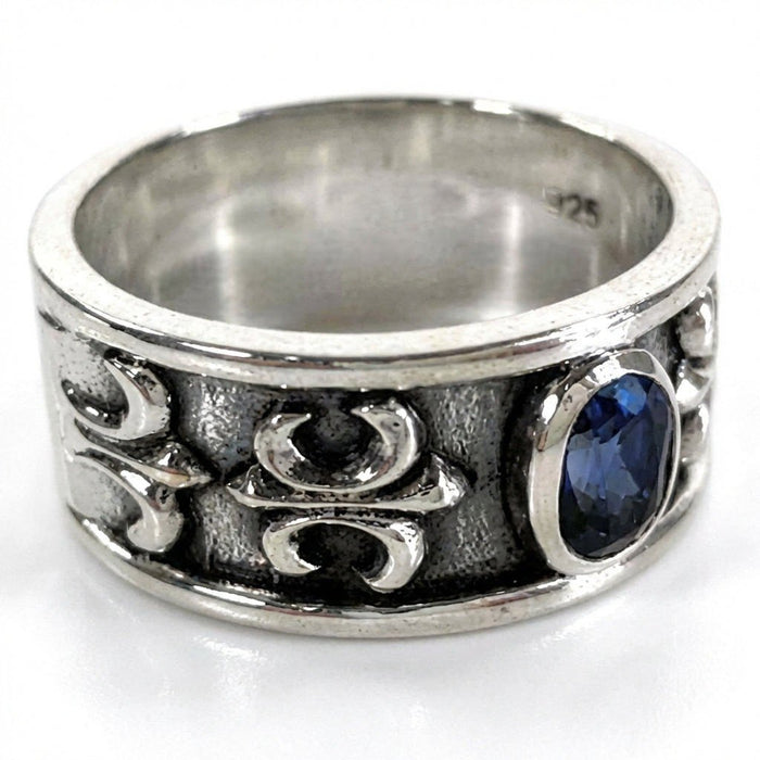 Close-up side angle displaying the raised fleur-de-lis pattern, oxidized background, and interior 925 silver hallmark.