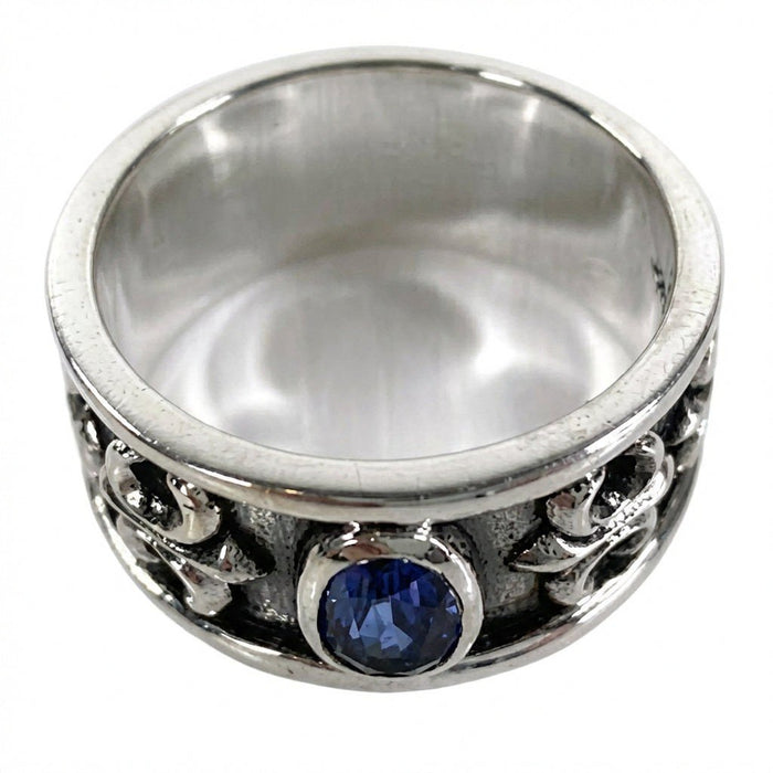 Elevated view showing the smooth polished inner silver band and front-facing deep blue cubic zirconia bezel setting.