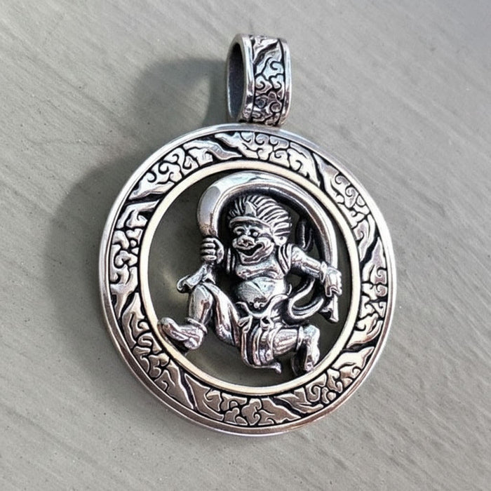An angled view of the handmade silver Fujin pendant, highlighting its 3D, openwork design.