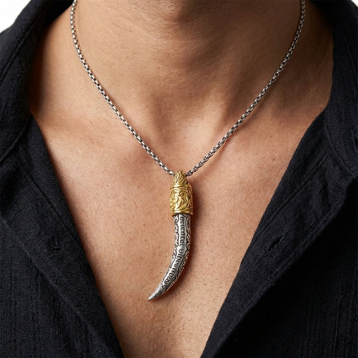 Ganesha tusk pendant necklace with ornate silver engraved tusk and gold brass cap on silver chain worn by man with open black shirt