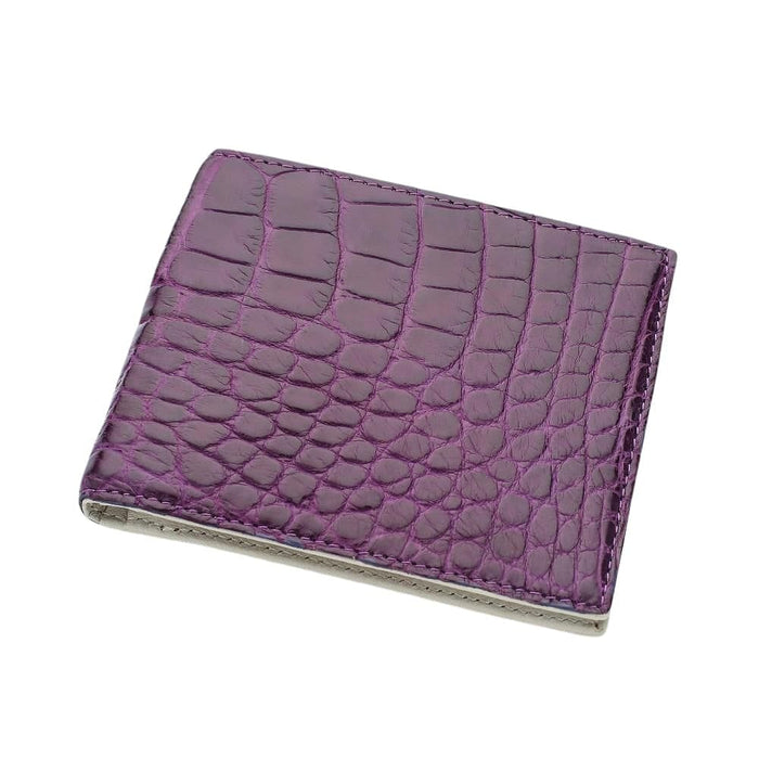 Three-quarter angle of the closed purple crocodile wallet showing edge stitching and the natural belly-scale texture.