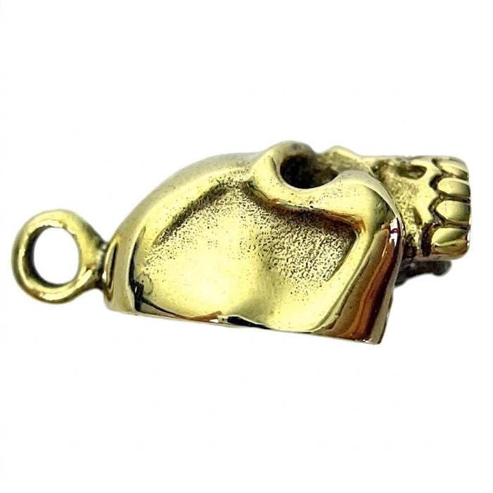 Right-facing side view of the split pendant, focusing entirely on the high-polished gold brass skull half and bail loop.