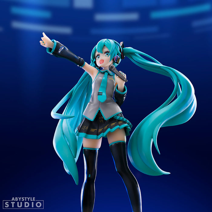 Anime character figurine with long turquoise hair and a microphone against a blue background, Abystyle Studio logo visible.
