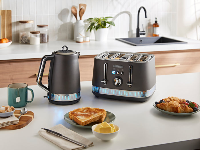 Kitchen scene with a toaster, kettle, and breakfast items on a counter.