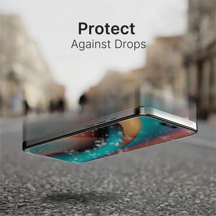 An iPhone 16 Pro Max with a Catalyst Case US Tempered Glass Screen Protector falls screen-first onto a hard street. The blurred urban background features trees and buildings. Bold text above the phone reads, "Protect Against Drops.