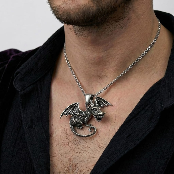 Close-up of a man wearing a detailed silver knight dragon pendant necklace on a chain. The intricately carved winged dragon rests on his chest, styled with an open black textured shirt.