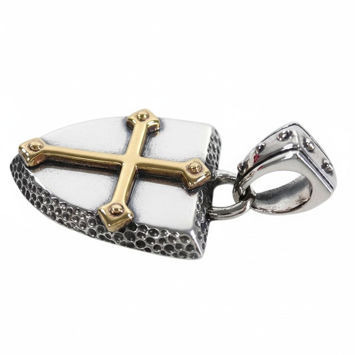 A close-up macro shot of the gold-plated cross on the textured sterling silver shield.