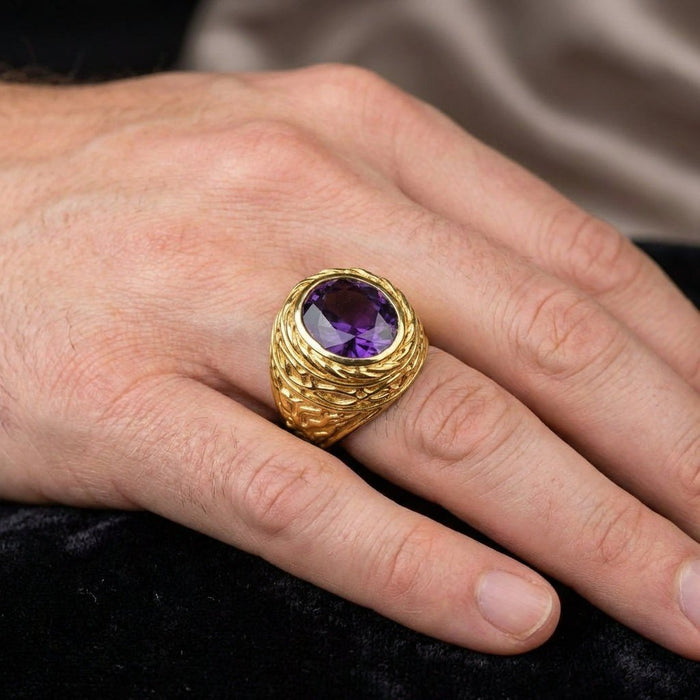 Men's hand wearing the textured gold ring, showcasing the vivid violet oval amethyst and raised lily petal details.