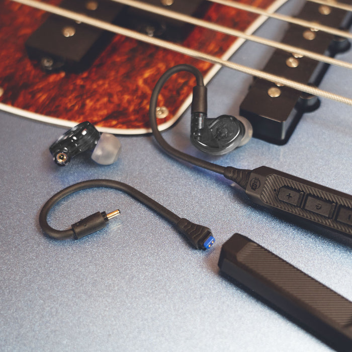 MEE audio M6 PRO Musicians' In-Ear Monitors Wired + Wireless Combo Pack: Includes IEMs, 2 Audio Cables and BT3 Hi-Res Bluetooth Audio Adapter w/aptX, LDAC, Auracast Support, & Built-In Headset (Black) displayed on a guitar.