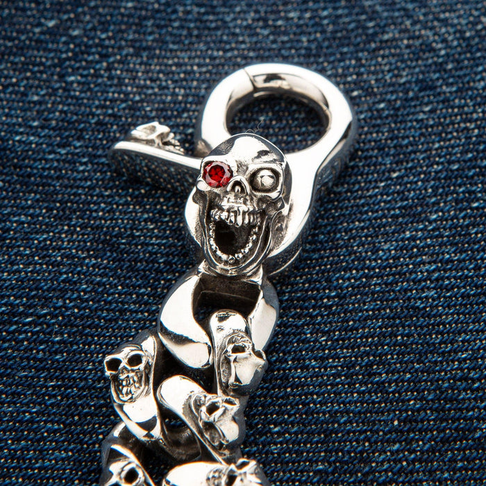 Close-up shot highlighting the red garnet stone set in the silver skull's eye socket.