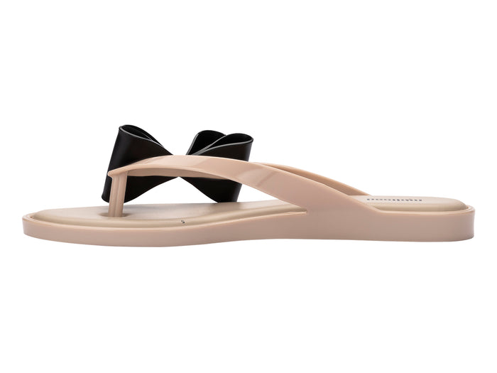 Melissa Flip Flop in beige with a cute flat bow design, stylish and comfortable slip-on footwear for women.
