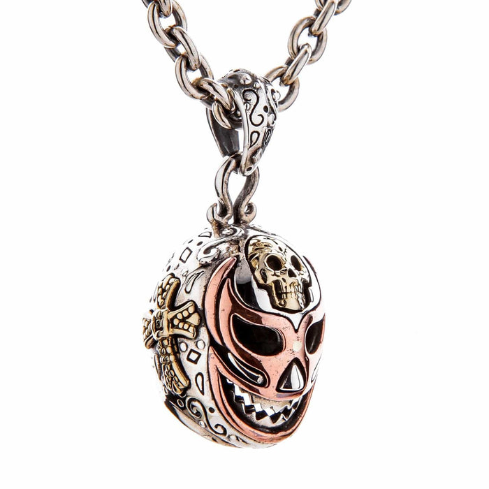An angled view of the Lucha Libre skull pendant, showing the brass cross detail.