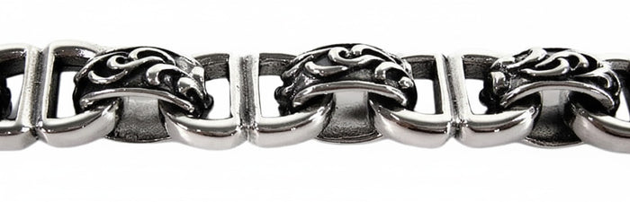 A close-up of the handcrafted tribal scrollwork links on the heavy 12mm silver bracelet.