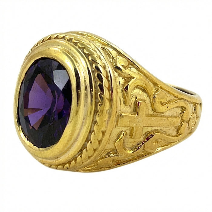 Top-down view of ornate yellow gold cross bishop ring featuring a large cabochon amethyst center stone