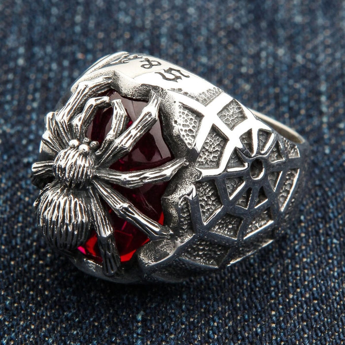 An angled view of the heavy silver biker spider ring on a denim background.
