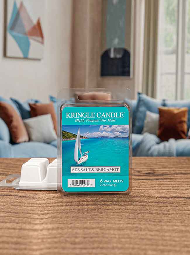 Kringle Candle Sea Salt & Bergamot wax melts on a wooden table, with a cozy living room in the background.