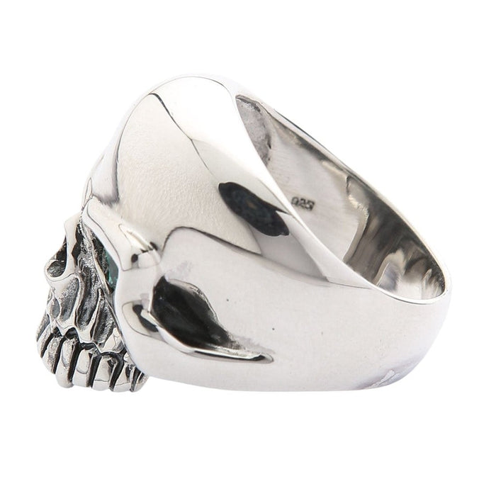 Statement skull ring with blue topaz eye right side view showing polished silver finish