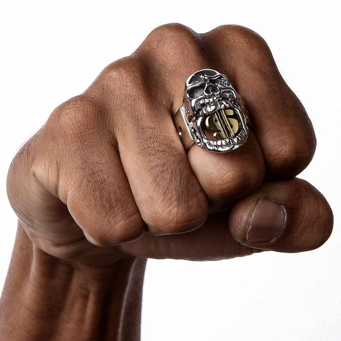 A man's hand wearing the heavy sterling silver dollar sign skull ring.