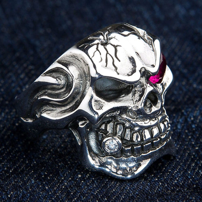 Angled view revealing the flame-detailed silver band, cracked skull forehead, and a clear gem on the cigar.