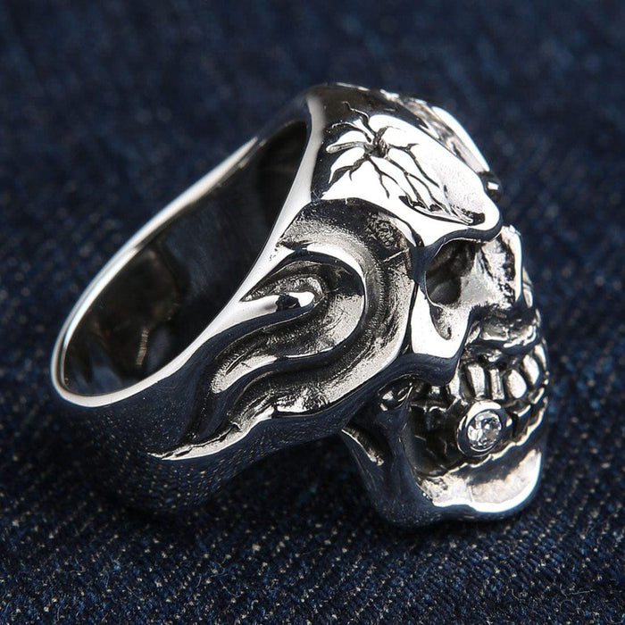 Side profile of the solid .925 silver skull ring displaying deep flame engravings and a clear stone set in the cigar.