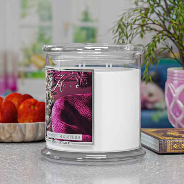Candle with a purple label on a surface with decorative items in the background