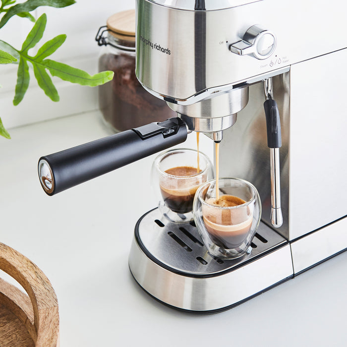 Coffee coming out of a coffee machine into two glasses at the same time